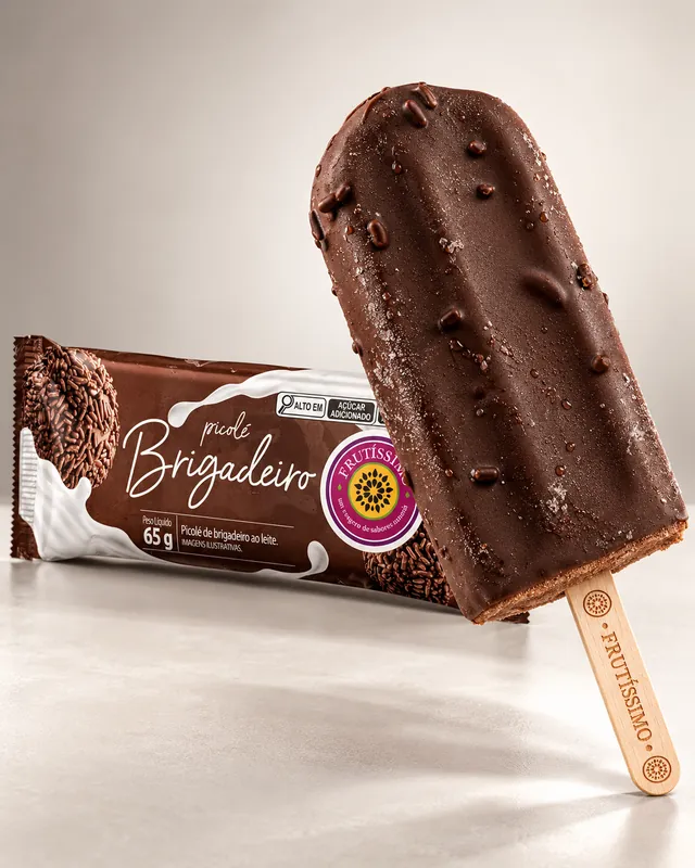 Picolé de brigadeiro Frutíssimo com cobertura de chocolate e granulado, ao lado da embalagem