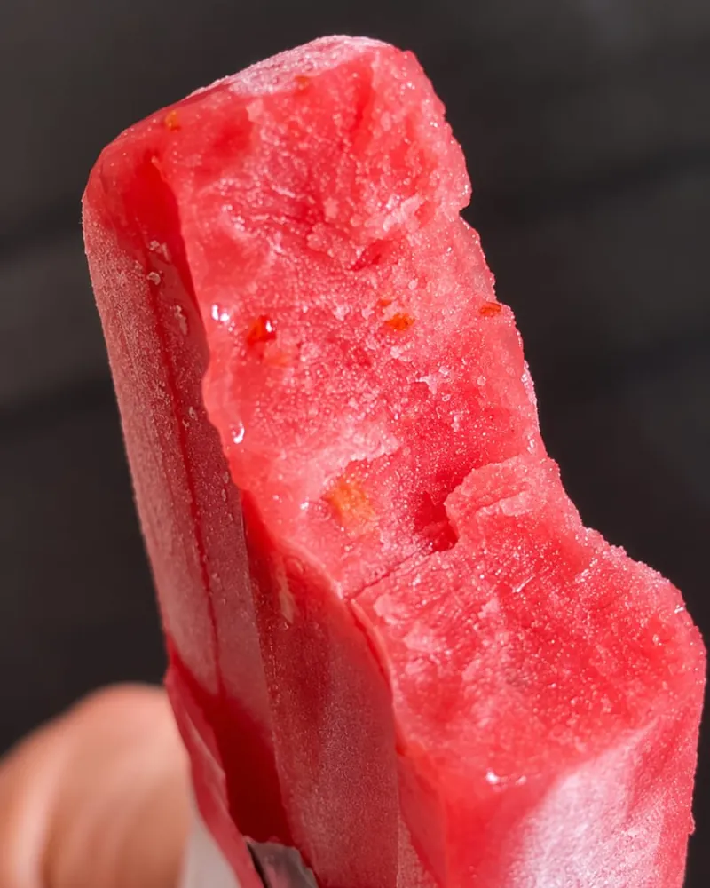 Picolé de morango Frutíssimo mordido, visto de perto, com pedaços da fruta